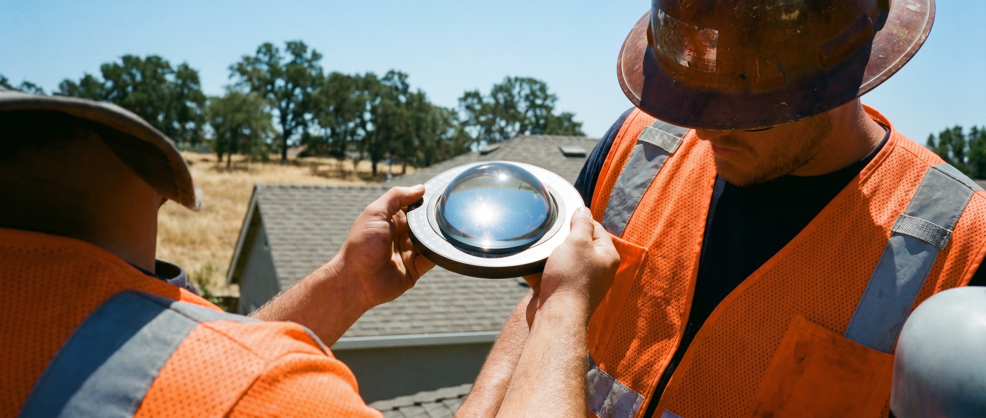 Helios crew member with a solar pathfinder tool on a Folsom 2nd-story roof at solar noon.